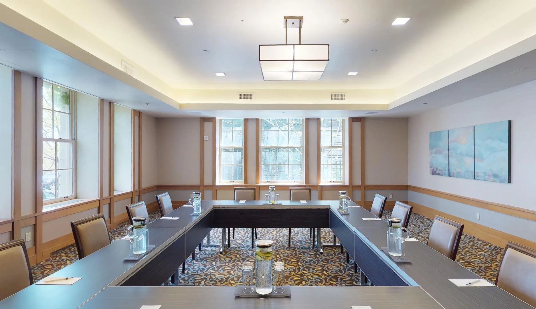 Tables and chairs arranged in a square for meetings